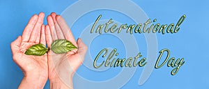 The inscription international climate day on a blue background with hands with a green sprout, background baner