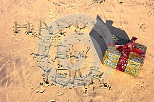 Inscription letters happy new year on the beach with gift on sand