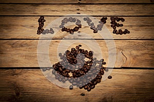 Inscription love made from coffee beans on wooden surface. dife photo