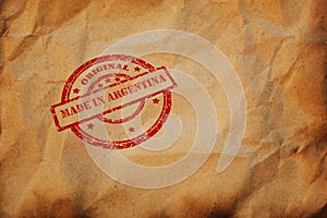 Inscription Made in Argentina stamp printed on crumpled sheet of burnt paper. Argentinean Product Business, parcel, package,