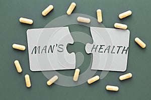 inscription male health on white disconnected puzzles, yellow pills on a green