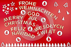 Inscription Merry Christmas in German, English, Polish, Swedish and Spanish, lying flat from above. Made of wooden inscriptions, i