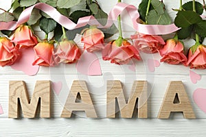 Inscription Mom with pink roses, ribbon and little hearts on wooden background
