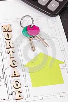 Inscription mortgage, keys and calculator on construction diagrams of house, buying home concept