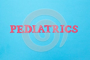 Inscription pediatrics in red letters on a blue background. Concept medical section dealing with the treatment of