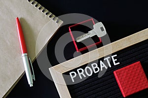 The inscription probate on a black board next to a notepad, pen and key in a red gift box. The concept of unexpected inheritance