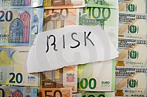 Inscription risk on a background of euros and dollars. Business concept.