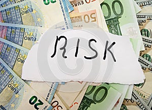 Inscription risk on a background of euros and dollars. Business concept.