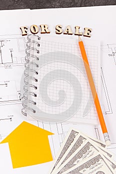 Inscription for sale, notepad and money on electrical diagrams, selling and buying house or flat concept