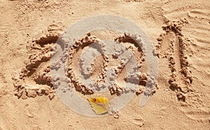 2021 inscription on the sand of the beach. Summer beach holidays in 2021. The message is handwritten