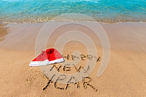 Inscription on the sand and cap of Santa Claus