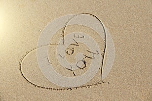 The inscription on the sand I love you. The heart is painted on the sand. Design with copy space. Top view