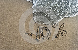 Inscription on the sand minus 10 percent, 10 %, sea wave on the
