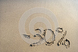 Inscription on the sand minus thirty percent, 30 %