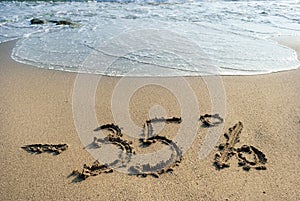 Inscription on the sand minus thirtyfive percent, 35 %, the sea