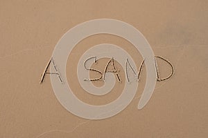 The inscription `Sand` painted on the sand.