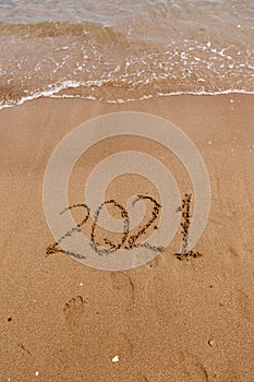 inscription on the sand 2021. symbol 2021 on the coast, overlooking the sea. Summer holidays in the new season.