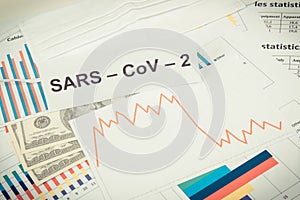 Inscription Sars-CoV-2, dollars and downward graphs representing financial crisis caused by Covid-19. Risk of recession around