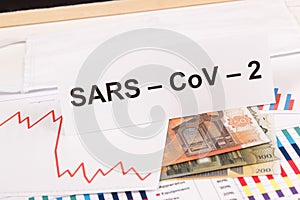 Inscription Sars-CoV-2, euro and downward graphs representing financial crisis caused by Covid-19. Risk of recession around world