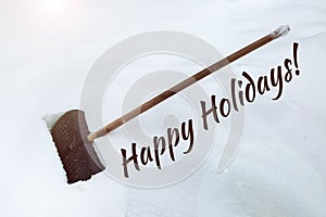 The inscription on the snow Happy Holidays. Big black plastic shovel in snowdrift. Cleaning of snow after heavy snowfall. Shovel