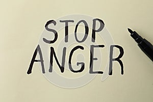 Inscription Stop Anger and black felt tip pen on beige background, top view