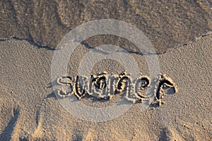 Inscription summer on wet sand. Holiday, rest and enjoyment