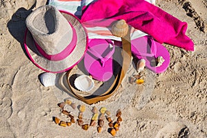 Inscription sun made of amber and different accessories for relax on sand. Straw hat, slippers and towel. Summer time on beach