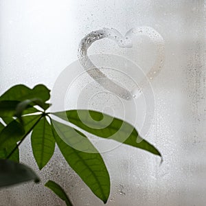 Inscription on the sweaty window glass, shape of heart. Love and romance symbol.