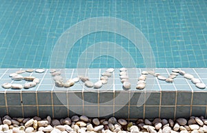 The inscription swim is laid out by pebble on a pool side
