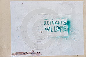 An inscription tagged on a white wall in Toulon that reads: Refugees Welcome 