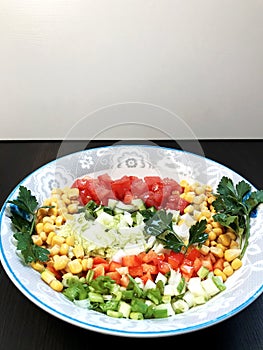 the inscription tasty and healthy with the image of a salad of fresh vegetables in a large plate