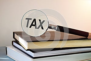 The inscription TAX is written on the immortal glass that lies on the books.