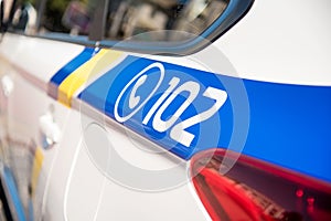 Inscription 102 - telephone number of the police on a patrol car
