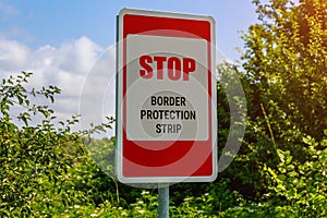 The inscription or text in English STOP BORDER PROTECTION STRIP. Warning post about the state border. Background