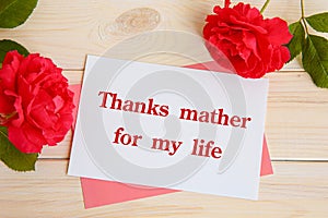 Inscription Thanks mather for my life. Red roses and a card