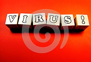 The inscription VIRUS on wooden cubes on a red background.