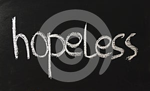 The inscription in white chalk on a black blackboard with the word hand hopeless