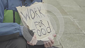 The inscription `Work for food` by the poor homeless tramp. Kyiv. Ukraine