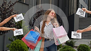 Inscriptions with discounts next to smiling girl with shopping bags. Low prices on Black Friday