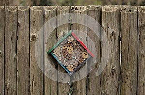 An insect hotel, also known as a bug hotel made of drilled wood and bark