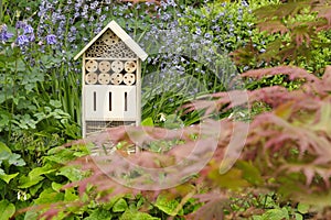 An insect hotel or bee hotel in a summer garden