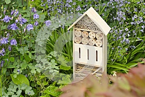 An insect hotel or bee hotel in a summer garden