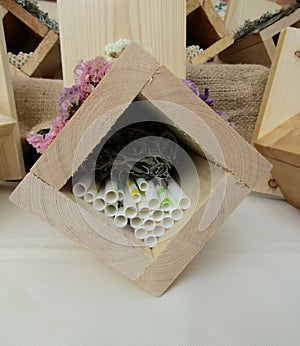 Insect hotels made of wooden boards, paper straws and moss