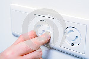 Inserting Baby Safety Plugs Into Wall Socket To Prevent Danger At Home