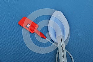 Inserting tip of a adult laryngeal mask airway (LMA). Image isolated on blue background.