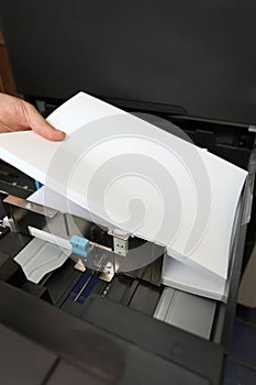 Inserts a paper A4 into a laser copier