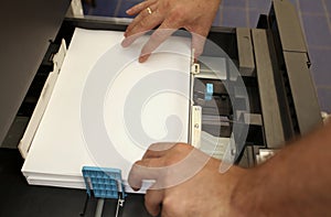 Inserts a paper A4 into a laser copier
