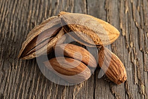 Inshell almonds on a background of rough wood texture