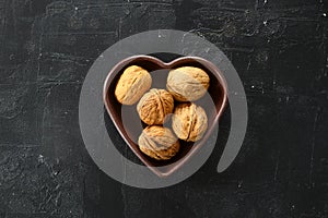 Inshell walnuts in a heart-shaped plate. Heart Nuts, Heart Health Products, Structured Walnuts Healthy food protein