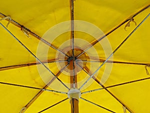 Inside a big yellow colored umbrella